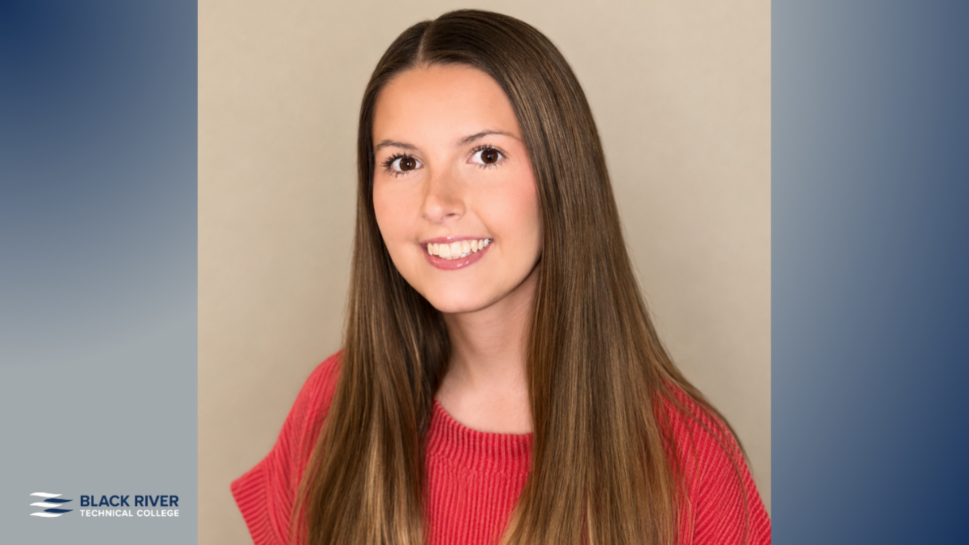 A young woman with long straight brown hair smiles in a studio portrait, wearing a red ribbed top against a tan backdrop.